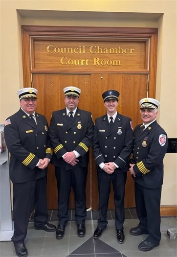 four members of the Summit Fire Department posing for a photo in front of Council Chamber Court Room