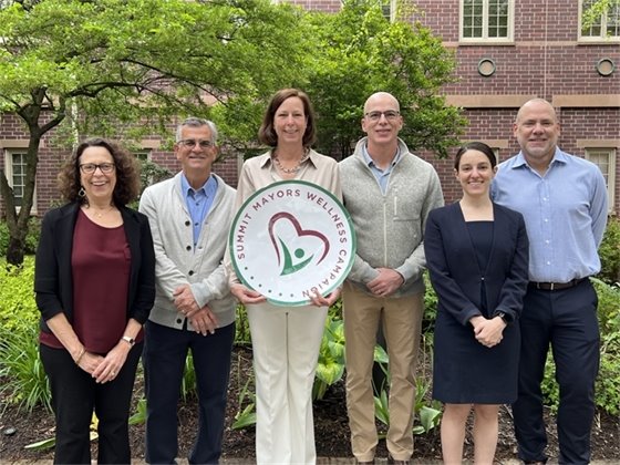 group photo in city hall courtyard with trees and brick building in background