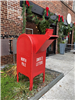 red Santa mailbox in front of a brick building