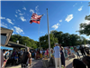 image of group of people gathered around a flagpole for Juneteenth event