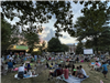 image of people sitting on the village green for a summer concert