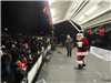 image of Mayor Radest and Santa Claus on the stage in front of people at the village green for the annual tree lighting