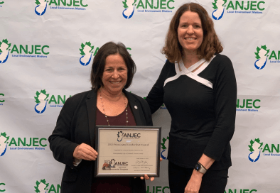 image of two women smiling at the camera one is holding a framed award