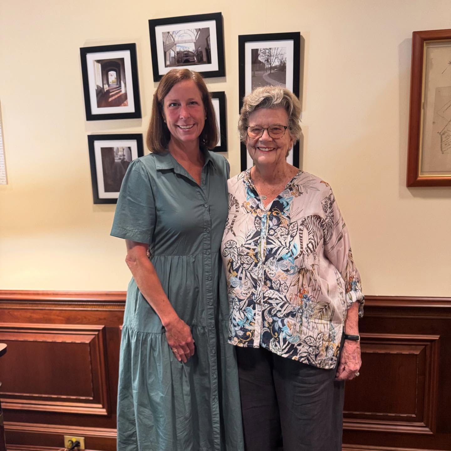 two people smile for a photo inside mayor's office