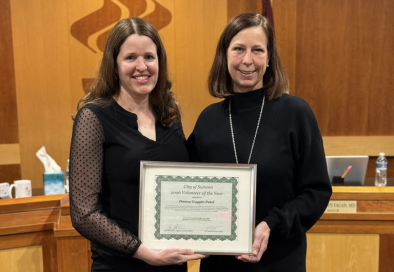 mayor and city volunteer holding framed award