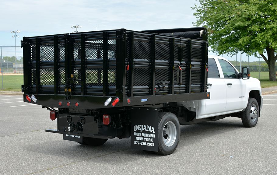 Photo of a white truck with a black storage port on its bed. 