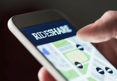 Image of hand holding phone with rideshare image on the screen
