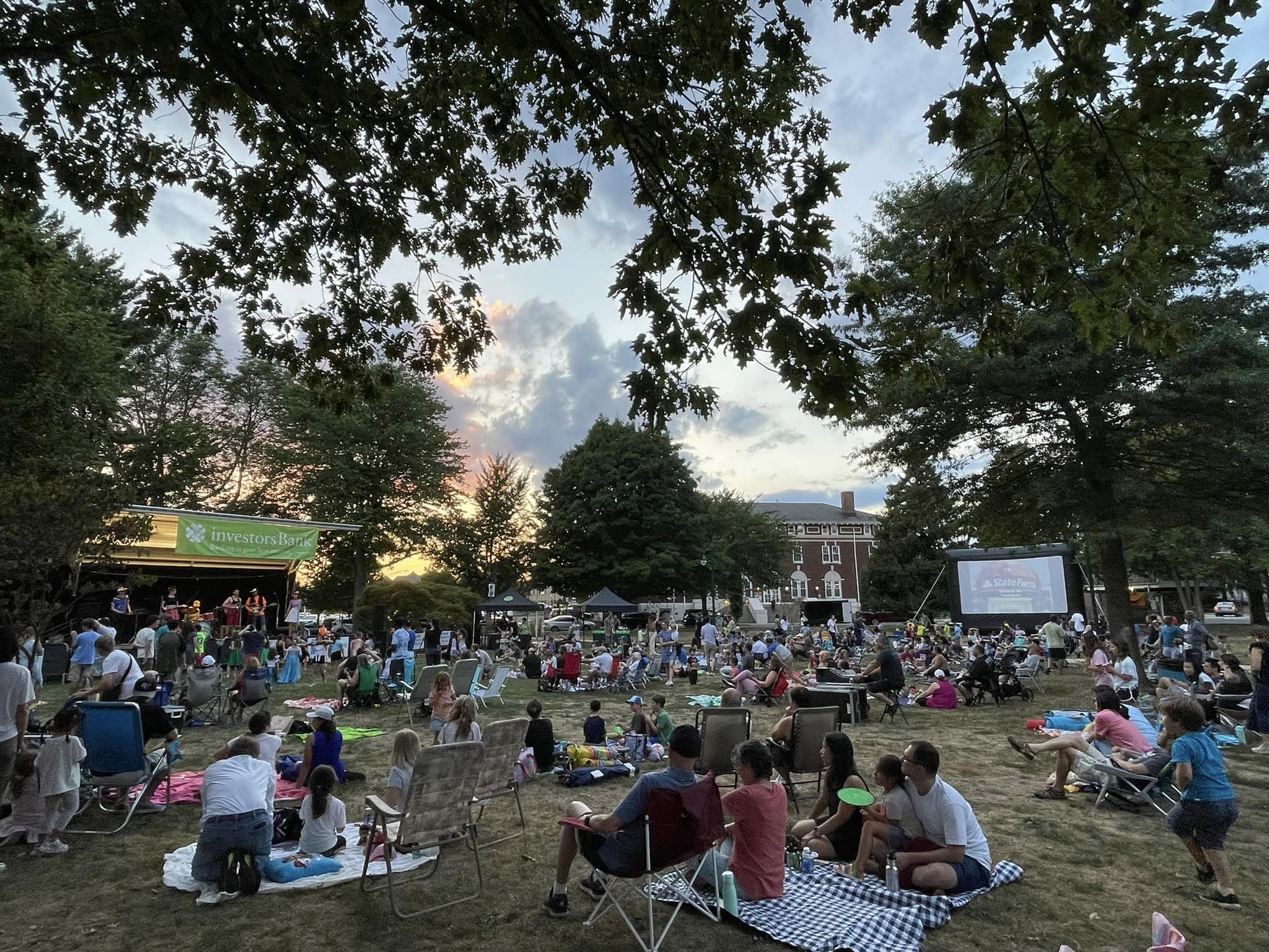 image of people sitting on the village green for a summer concert
