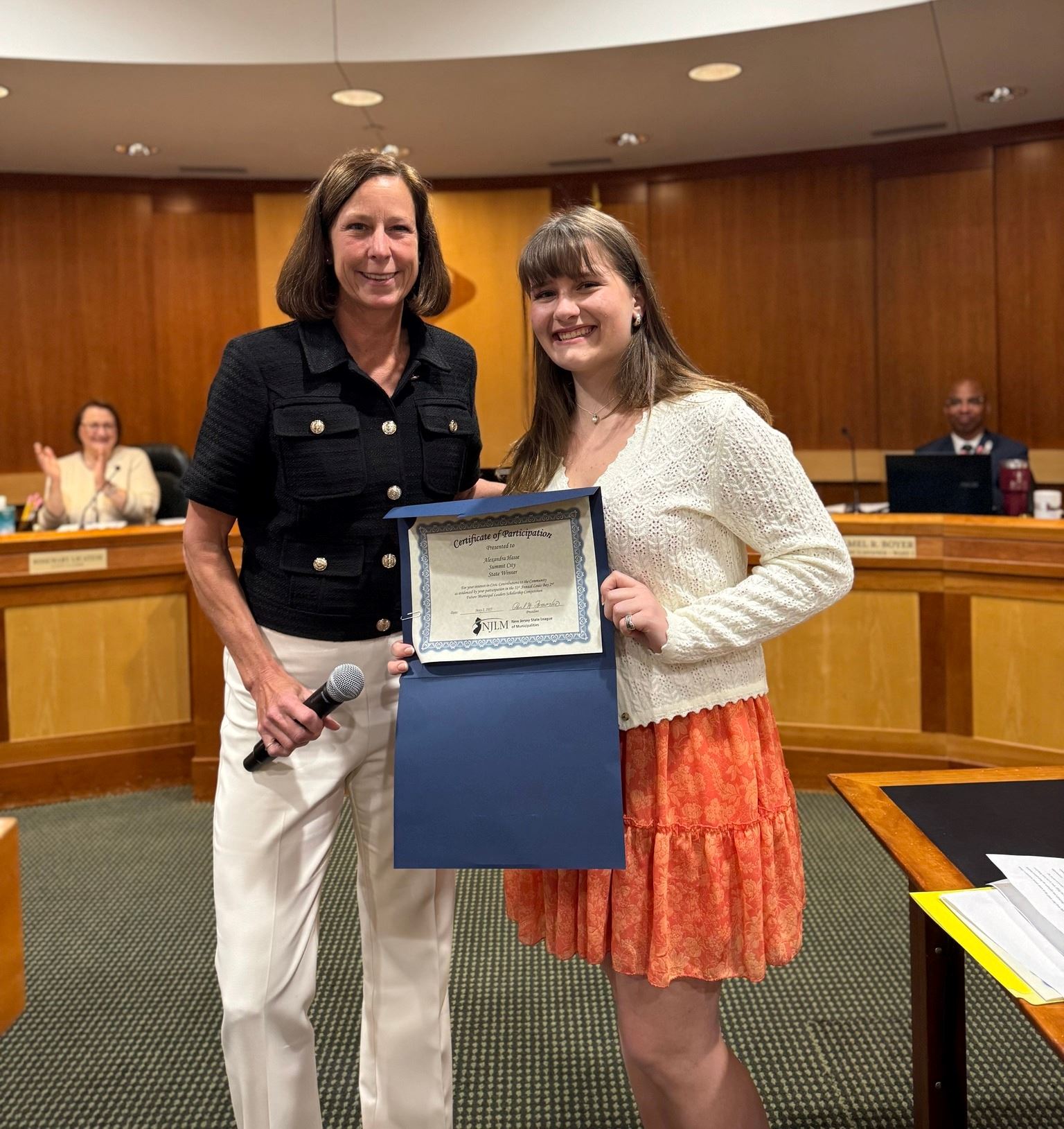 mayor and student posing for photo in council chamber