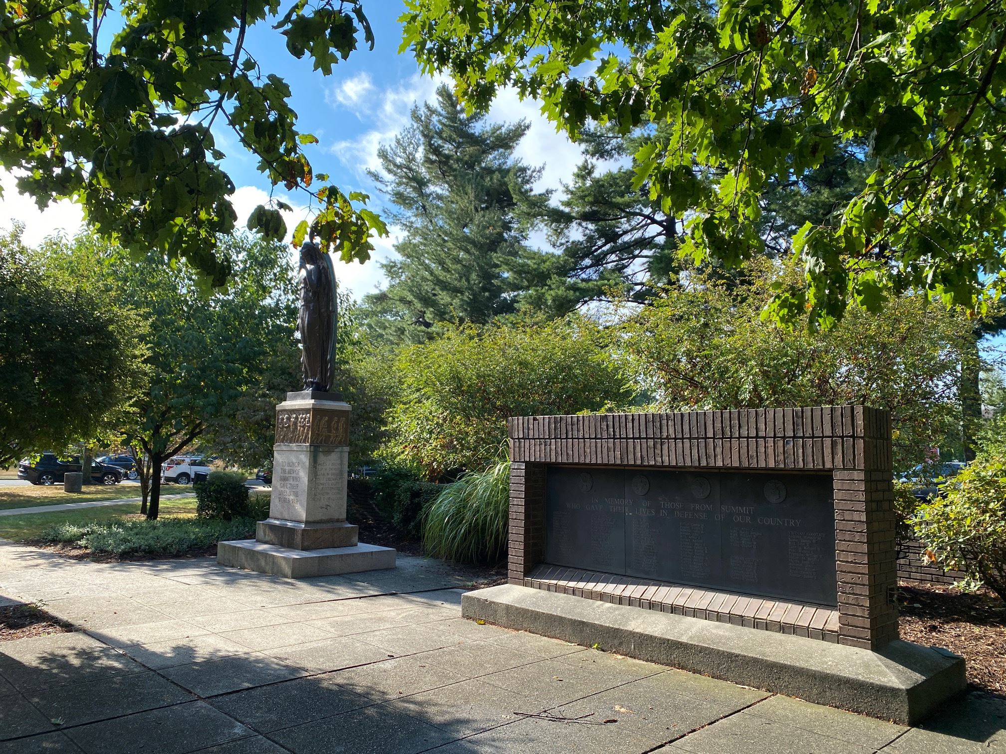 photo of monuments on village green with trees and blue sky in the background
